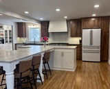 Open-concept kitchen remodel with T-shaped island and hardwood flooring in Hopkins, MN